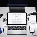 Modern Laptop Work Setup With Connected Smartphone Charger Passport Watch And Pen