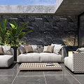 Stylish Outdoor Sofa Patio Setting With Plush Cushions And Green Plants By Stone Wall