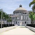 Grand Hotel Building Featuring Large Dome And Palm Trees With Neat Shrubs Along Main Pathway