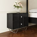 Black Bedside Table with Round Panels Metal Legs and Clear Vase Holding White Pink Flowers