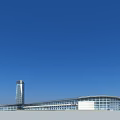 Modern Urban Architecture With Tall Glass Tower And Curved Low Rise Building Under Blue Sky