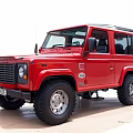 Red Land Rover Defender Classic Off Road Vehicle With Black Tires And Roof Rack