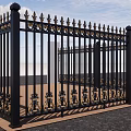 Ornate European Style Entrance Gate With Black Iron And Golden Decorations Open Under Blue Sky