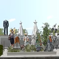 Mannequins in Various Outfits Displayed Outdoors With Green Plants Trees and Blue Sky