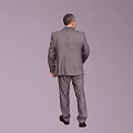 A Man Standing in Gray Suit with White Shirt and Black Vest on Gray Background