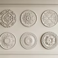 Various Decorative Ceiling Medallions Featuring Carved Patterns On Light Colored Panel 3d model