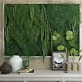 Lush Green Plant Wall In Indoor Space With White Vase Picture Frame And Decorative Items
