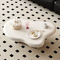 Stylish White Irregular Coffee Table With Checkered Basket Pink Glass Donuts And Golden Spoon