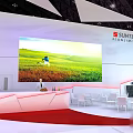 SUNTECH Exhibition Booth Red White Design With Top Logo Large Screen And Green Field
