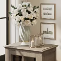 Light White Vase With White Flowers On Wooden Cabinet With Glass Candle Holders And Paintings
