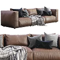 Brown Three Seater Leather Sofa With Gray Black Pillows And Striped Blanket