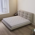 Double Bed With Light Beige Upholstered Headboard And Quilted Mattress Near Nightstand With Table Lamp
