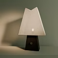 Minimalist Table Lamp Featuring Geometric Fabric Shade And Dark Wooden Base With Lit Bulb