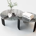 Modern Round Glass Top Coffee Table With Black Metal Legs And Decorative Books Vase