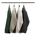 Various Colored Knitted Round Neck Sweaters Hanging On Black Hangers