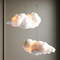 Two Cloud Shaped Pendant Lights With Warm Yellow Glow For Indoor Ambiance Design