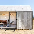 Modern Guesthouse Building In Field With Illuminated Interior And Outdoor Seating