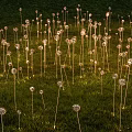 Illuminated Garden Landscape With Decorative Metal Flowers In Green Grass Field