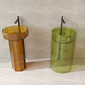 Transparent Column Shaped Brown And Green Pedestal Washbasins Against Light Colored Wall