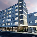 Modern Multi Storey Building With Glass Facade Trees And Evening Sky View