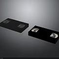Vintage Electronic Storage Devices With Two Black VHS Tapes