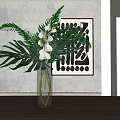 Transparent Glass Vase With White Orchids Large Green Leaves And Abstract Art On Textured Wall