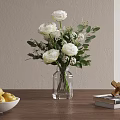 Transparent Glass Vase With White Flowers And Green Leaves On Wooden Table With Books
