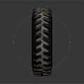 Large Industrial Tire With Deep Tread And Worn Metallic Rim On Dark Background