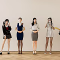 Women In Different Outfits Standing And Sitting Against Light Colored Wall With Wooden Floor