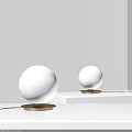 Modern Spherical Table Lamps with White Shades and Gold Bases on White Surfaces