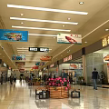 Bright Department Store Interior With Spacious Aisles Advertising Banners Shoppers Flower Bed Benches Signage