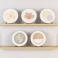Neutral Toned Decorative Plates With Floral Leaf Patterns On Wooden Shelves