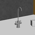 Stainless Steel Faucet On White Countertop With Marble Object And Red Accessory