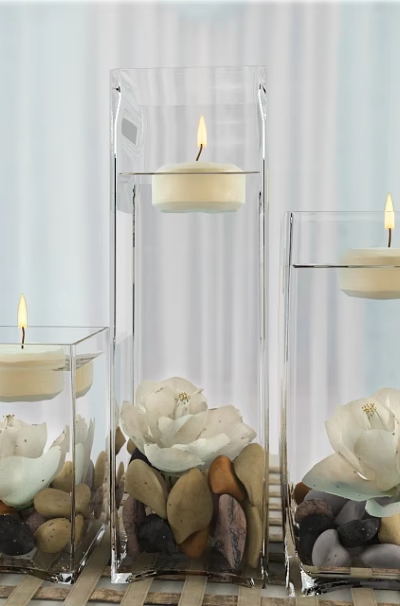 Transparent Glass Candle Lamps With Lit Candles White Flowers And Pebbles On Tabletop 3d model