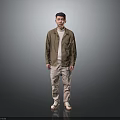 Man in brown shirt white undershirt khaki pants beige shoes against gray black gradient background