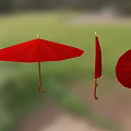 Red Umbrellas Open And Folded Hanging Against Green Outdoor Background