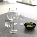 Elegant Modern Decorative Ornament Set With Glassware Black Bowl Green Fruits On Gray Countertop
