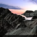 Breathtaking Garden Landscape With Snow Covered Mountains Rocky Terrain Calm Lake And Sunset Sky