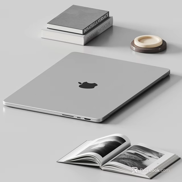 Silver Apple Laptop on Desk with Stacked Books Open Magazine and Coaster 3d model 