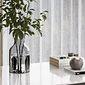 Green Leafy Plants in Transparent Vase on White Table with Curtain and Decorative Books