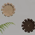 Flower Shaped Wooden Clocks in Light and Dark Wood on Light Wall with Green Fern Plant