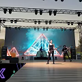 Outdoor Evening Stage With Metal Truss Lighting LED Screen Band Neon Decorations And Grass Background