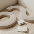 Minimalist Beige Fabric Sofa Stools With Round Design On Wooden Floor And Open Books