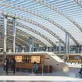 Modern Train Station Architecture With Glass Roof Metal Columns And Wooden Waiting Areas