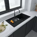 Modern Kitchen Black Sink With Running Faucet White Countertop Cutting Board Oranges And Gray Cabinets