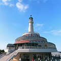 Scenic White Lighthouse With Circular Base Staircase And People Under Blue Sky White Clouds