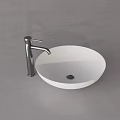 Modern White Round Above Counter Washbasin with Silver Faucet on Gray Countertop