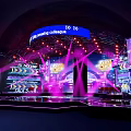 Dynamic Stage Design Featuring Purple Lighting LED Screens And Blue Amazing Collage Banner