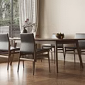 Wooden Dining Table Set with Gray Upholstered Chairs Vase Flowers Fruit Bowl and Natural Light