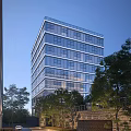 Modern Office Building With Glass Curtain Wall Surrounded by Trees Under Blue Sky